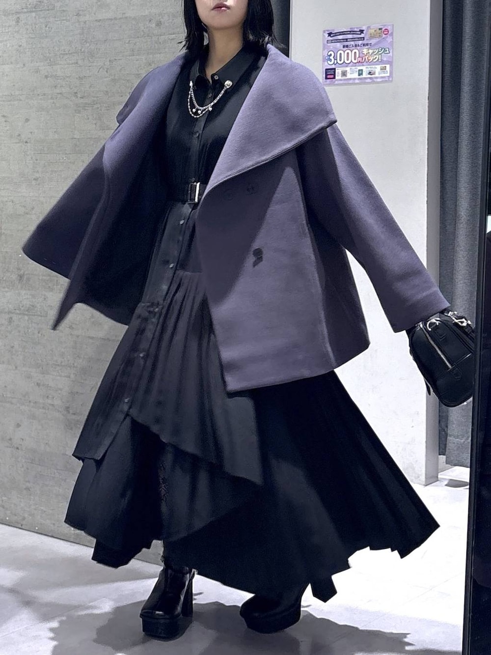 パープル系のチェスターコート、ブラック系のボストンバッグ、ブラック系のブーツを着用したレディースの冬コーディネートの4枚目の写真