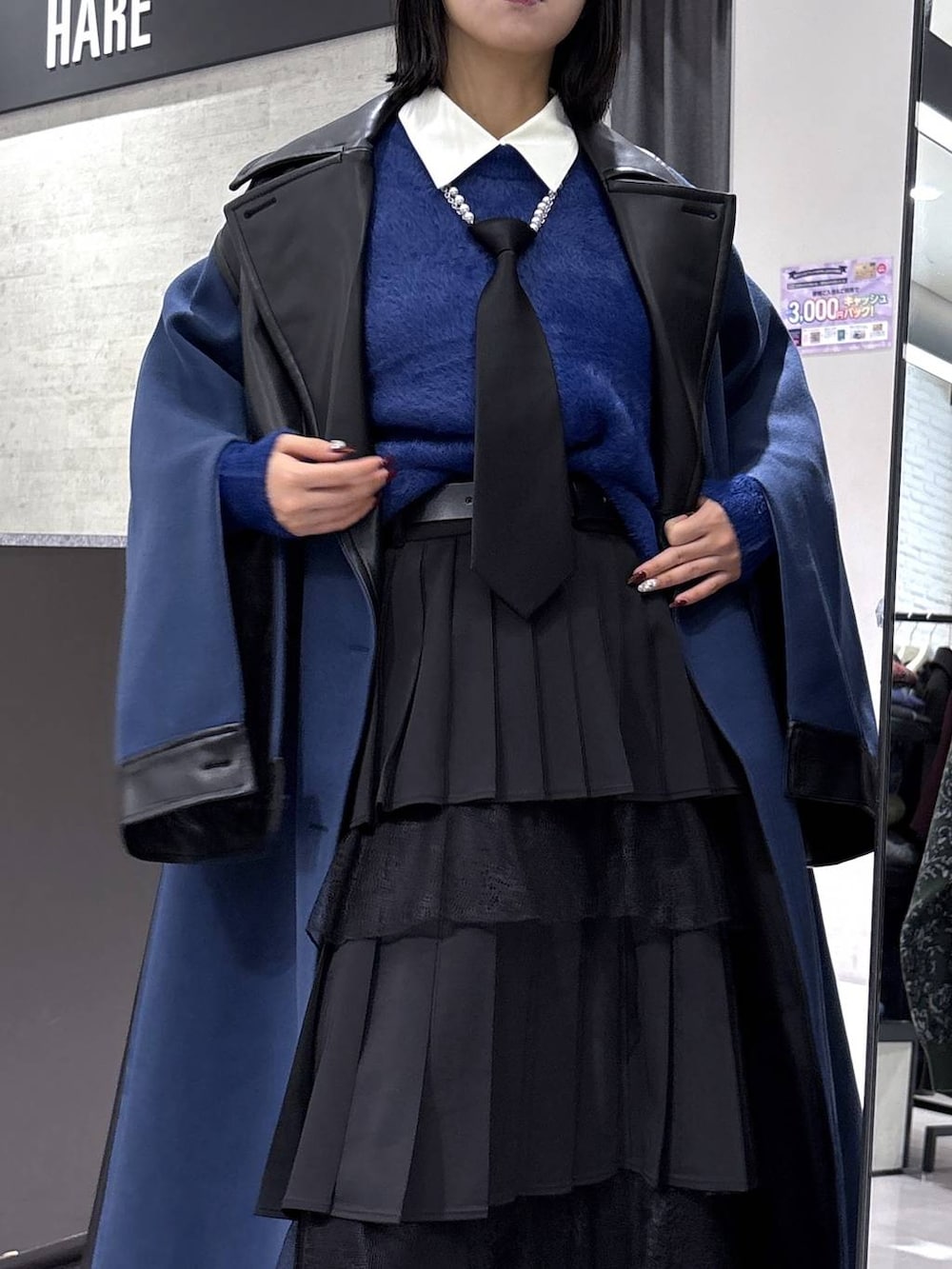 ブラック系のネクタイ、ブルー系のチェスターコート、ブルー系のニット/セーターを着用したレディースの冬コーディネートの8枚目の写真