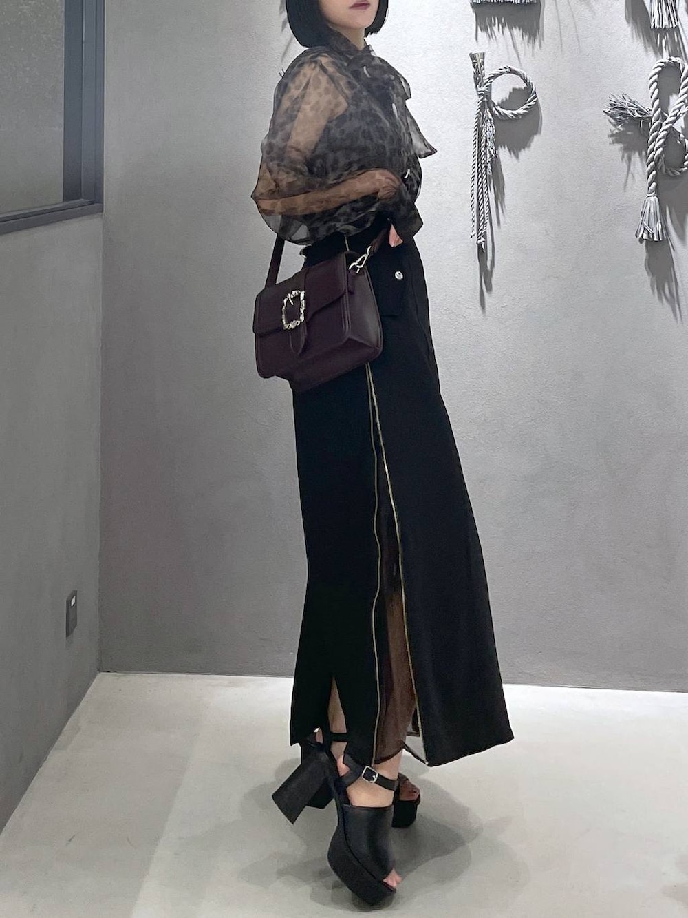 ブラック系のタンクトップ、ブラック系のサンダル、ブラウン系のショルダーバッグを着用したレディースの夏コーディネートの4枚目の写真