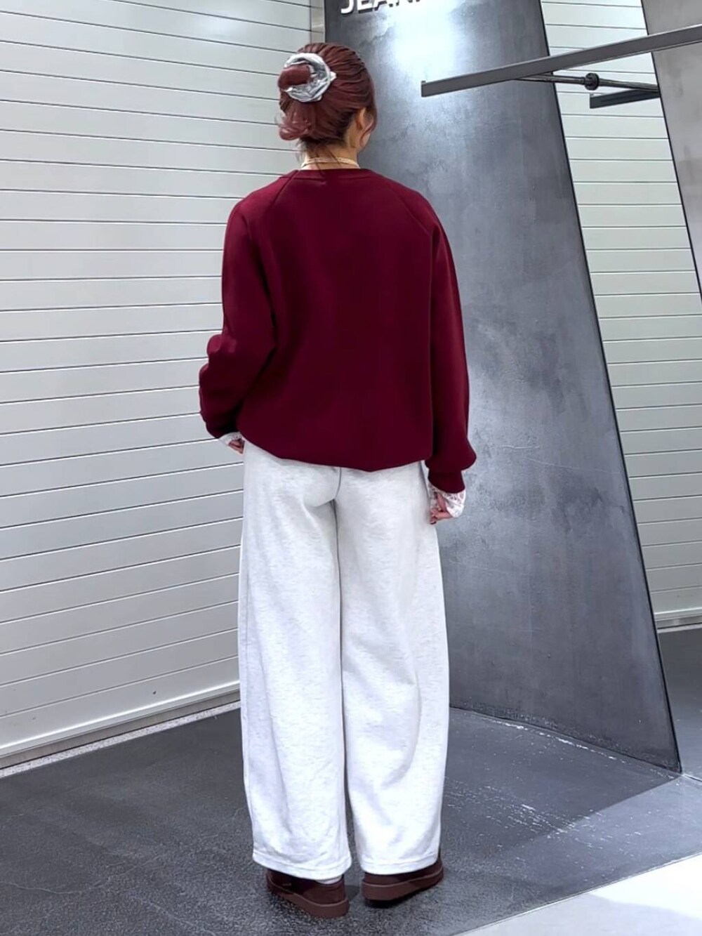 ブラウン系のその他シューズ、レッド系のニット/セーター、ベージュ系のスウェットパンツを着用したレディースの秋コーディネートの5枚目の写真