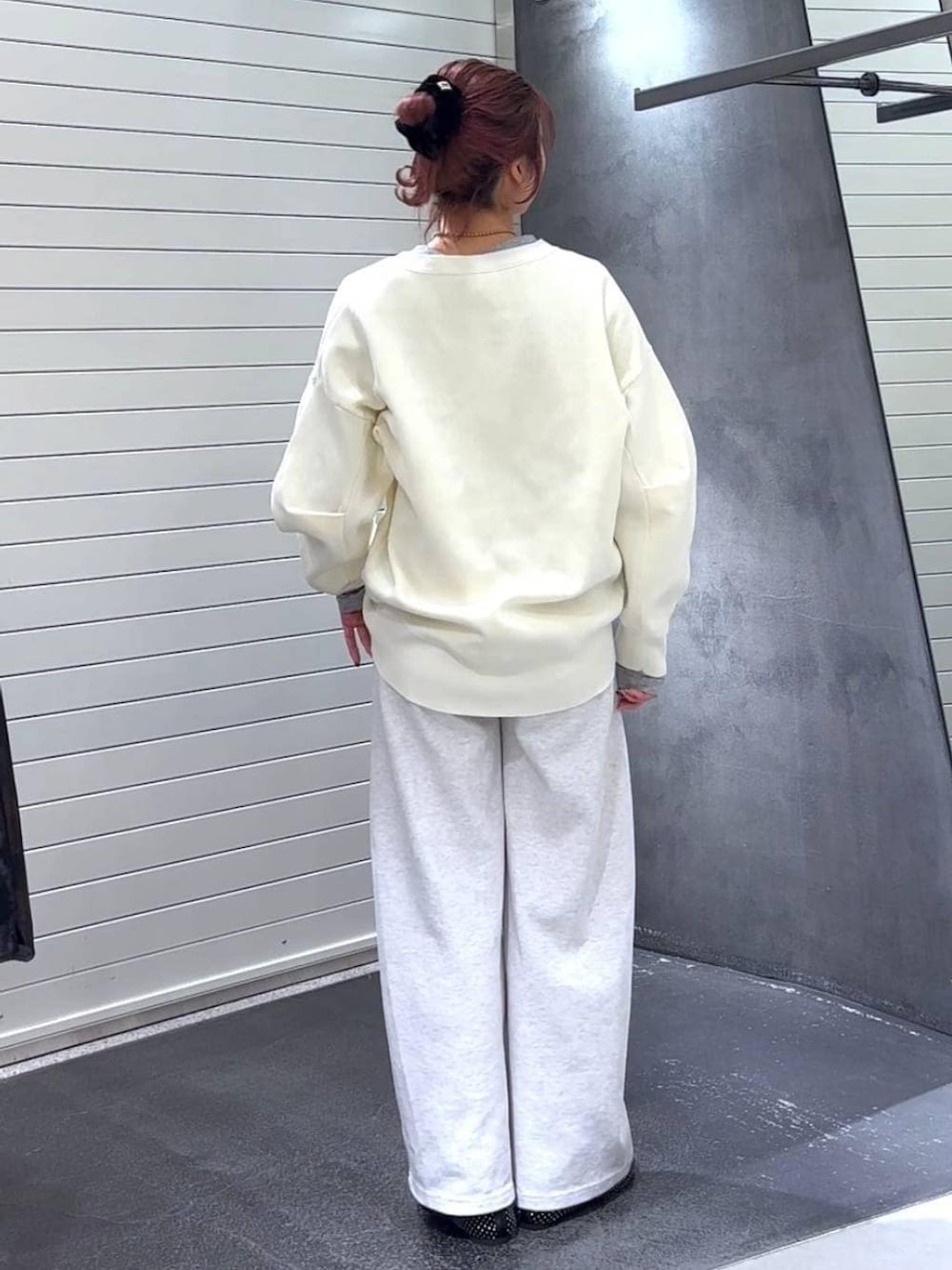 ブラック系のパンプス、グレー系のTシャツ/カットソー、ベージュ系のスウェットパンツを着用したレディースの冬コーディネートの5枚目の写真