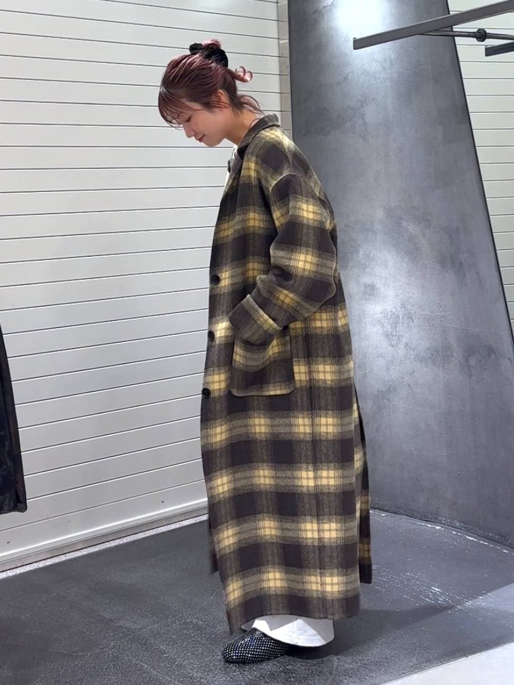 ブラウン系のチェスターコート、ブラック系のパンプス、グレー系のTシャツ/カットソーを着用したレディースの冬コーディネートの6枚目の写真