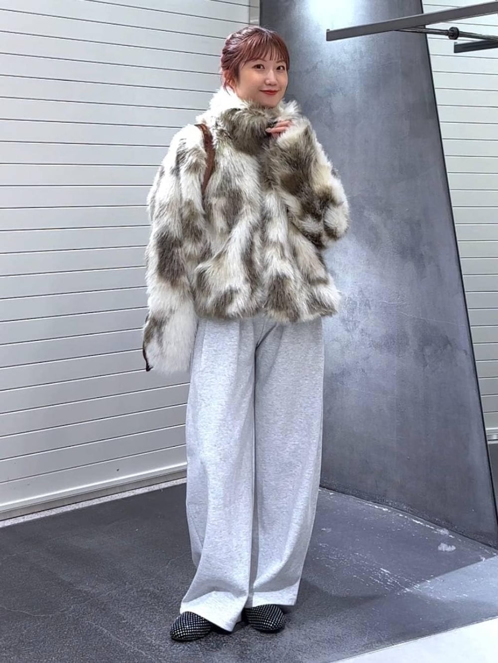 ホワイト系のブルゾン、ブラウン系のトートバッグ、グレー系のスウェットパンツを着用したレディースの冬コーディネートの3枚目の写真