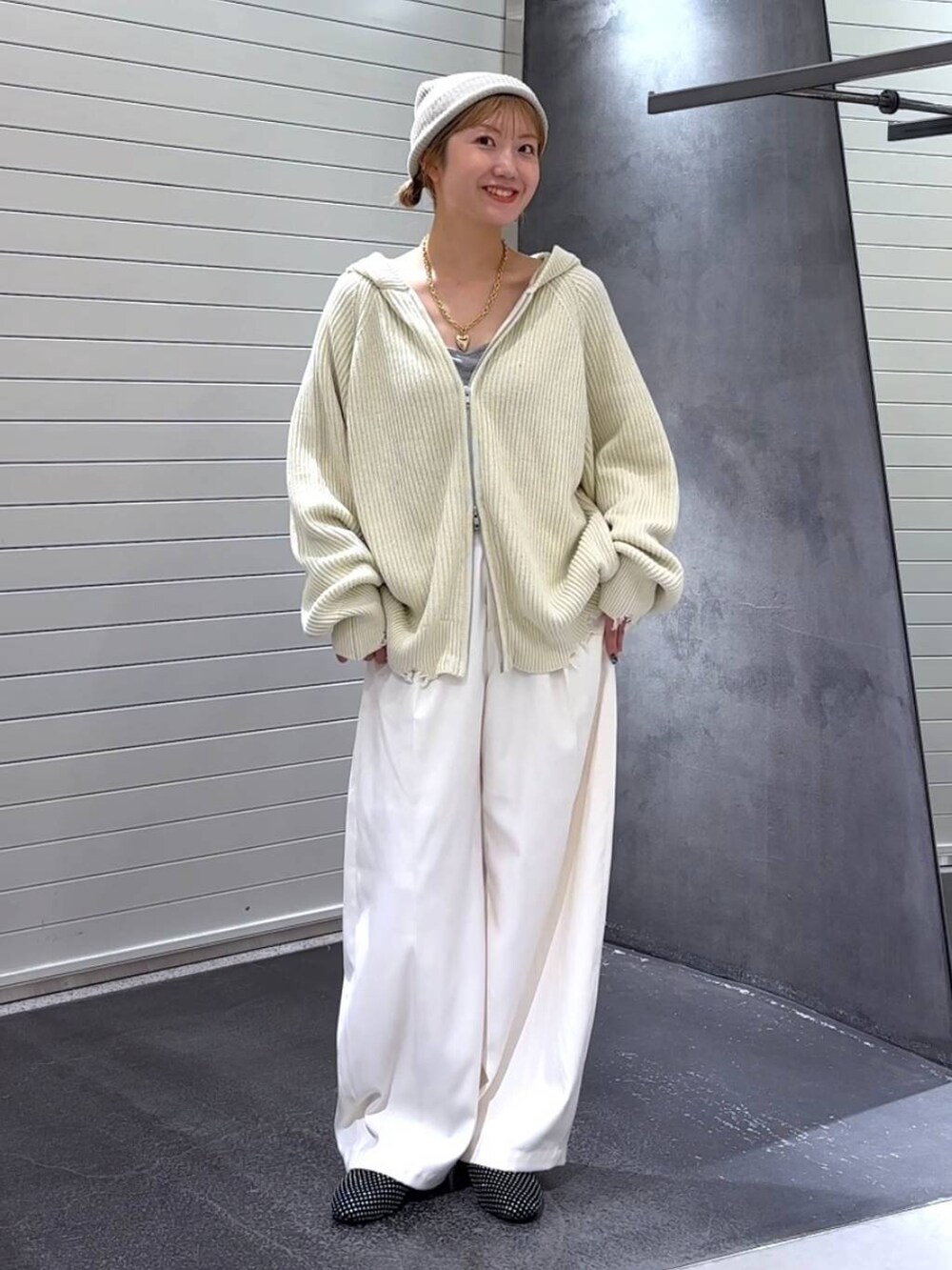 ブラック系のパンプス、ホワイト系のスラックス、ホワイト系のパーカーを着用したレディースの秋コーディネートの2枚目の写真