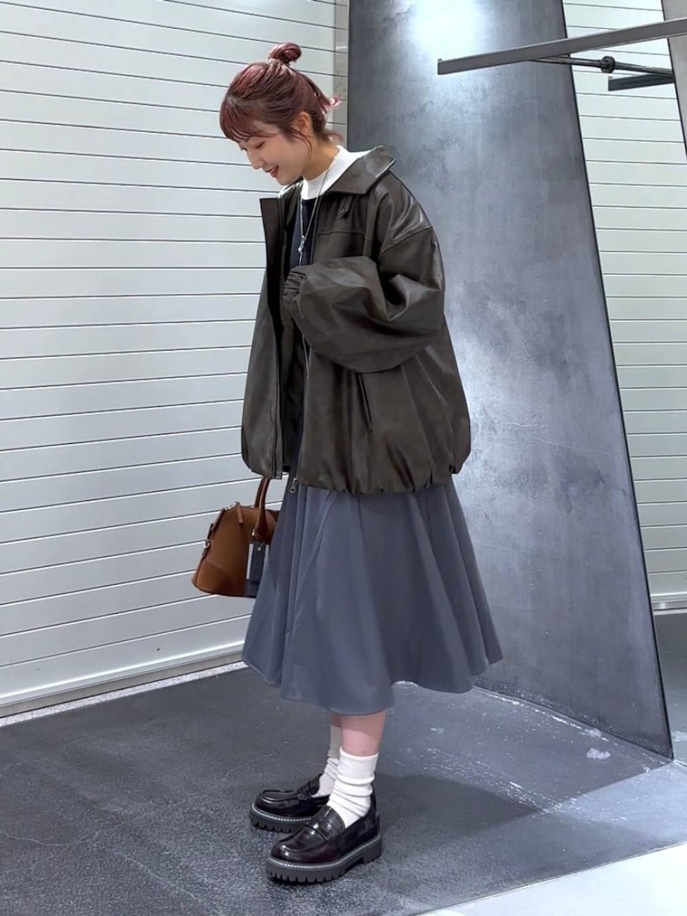 ブラウン系のブルゾン、ブラウン系のローファー、ブラウン系のボストンバッグを着用したレディースの秋コーディネートの6枚目の写真