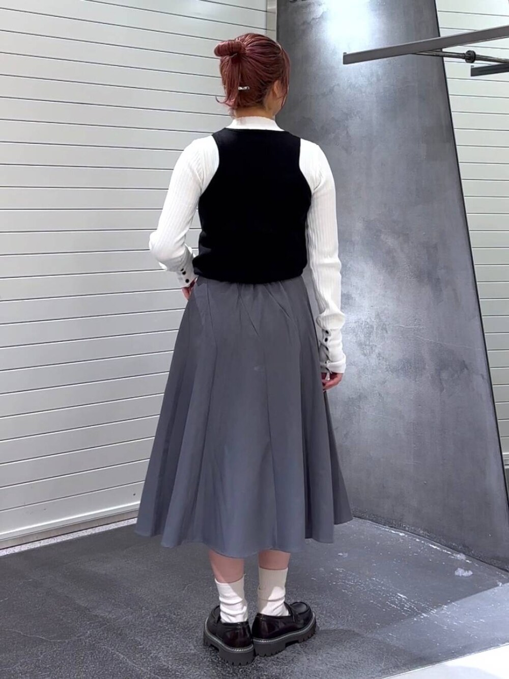 ブラウン系のローファー、ホワイト系のニット/セーター、グレー系のスカートを着用したレディースの秋コーディネートの5枚目の写真