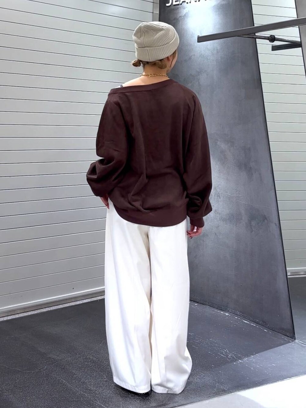 ブラック系のパンプス、ブラウン系のスウェット、ホワイト系のスラックスを着用したレディースの秋コーディネートの5枚目の写真