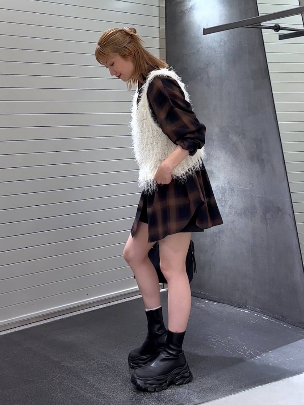 ブラウン系のシャツ/ブラウス、ブラック系のブーツ、ブラック系のボストンバッグを着用したレディースの秋コーディネートの6枚目の写真