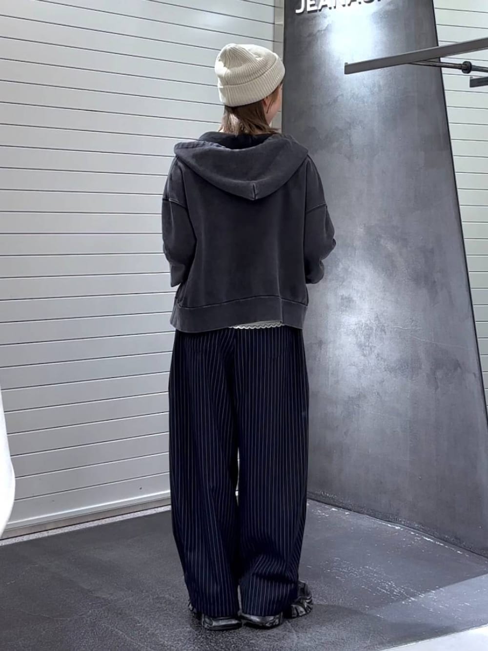 ホワイト系のTシャツ/カットソー、ブラック系のパーカー、ブラック系のスニーカーを着用したレディースの秋コーディネートの5枚目の写真