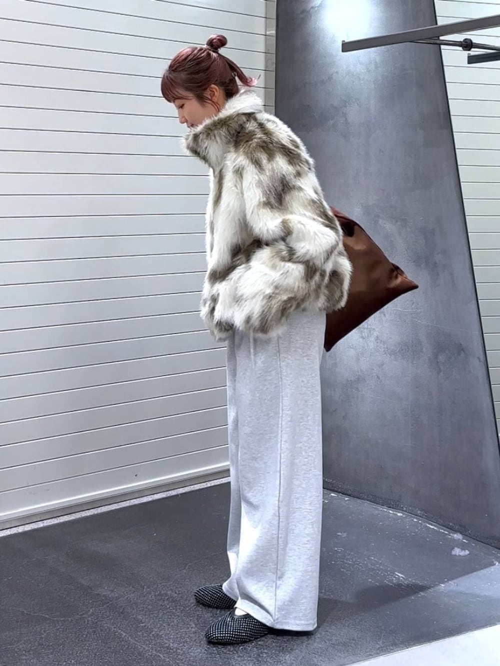 ホワイト系のブルゾン、ブラウン系のトートバッグ、グレー系のスウェットパンツを着用したレディースの冬コーディネートの6枚目の写真