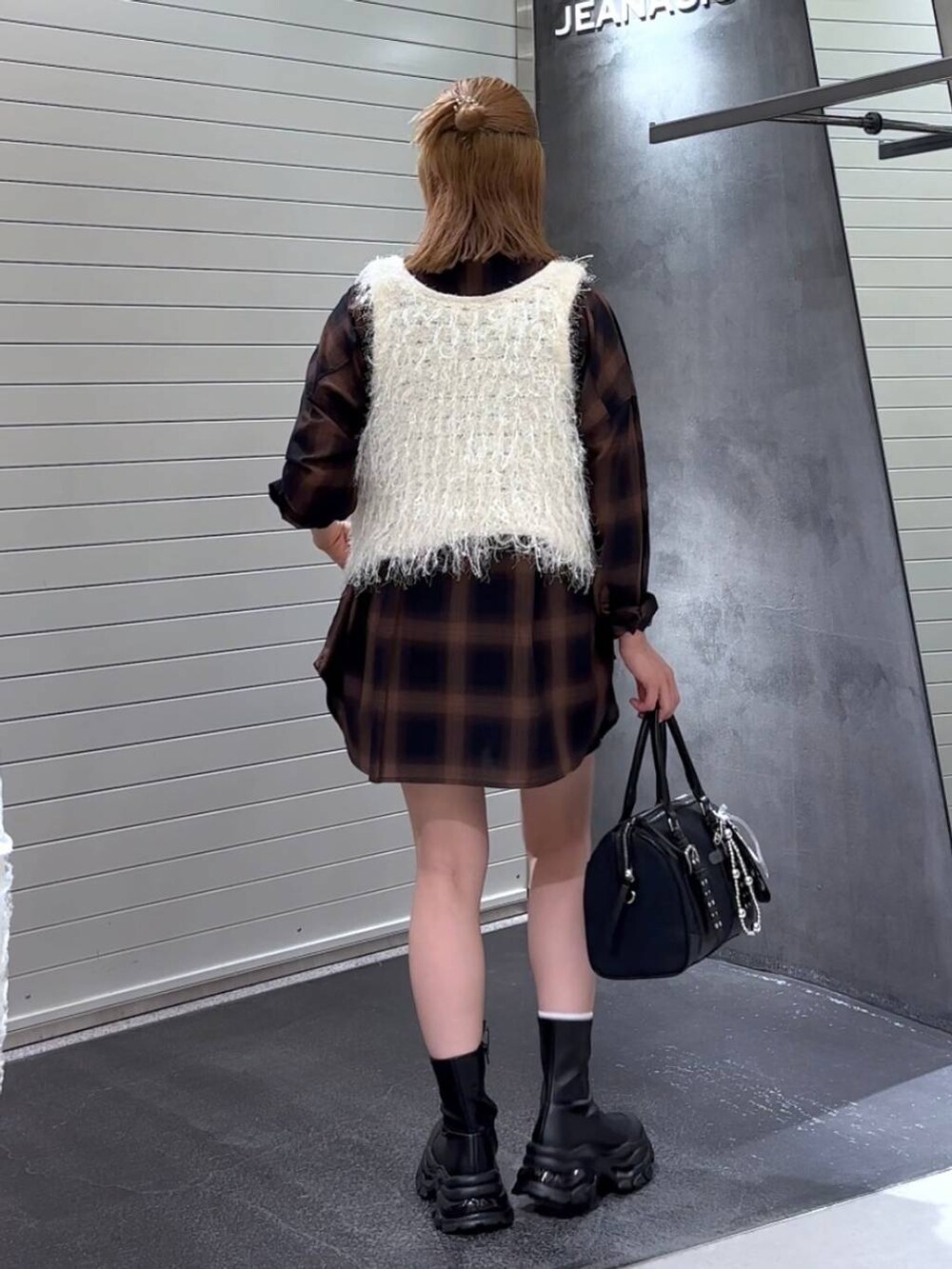 ブラウン系のシャツ/ブラウス、ブラック系のブーツ、ブラック系のボストンバッグを着用したレディースの秋コーディネートの5枚目の写真