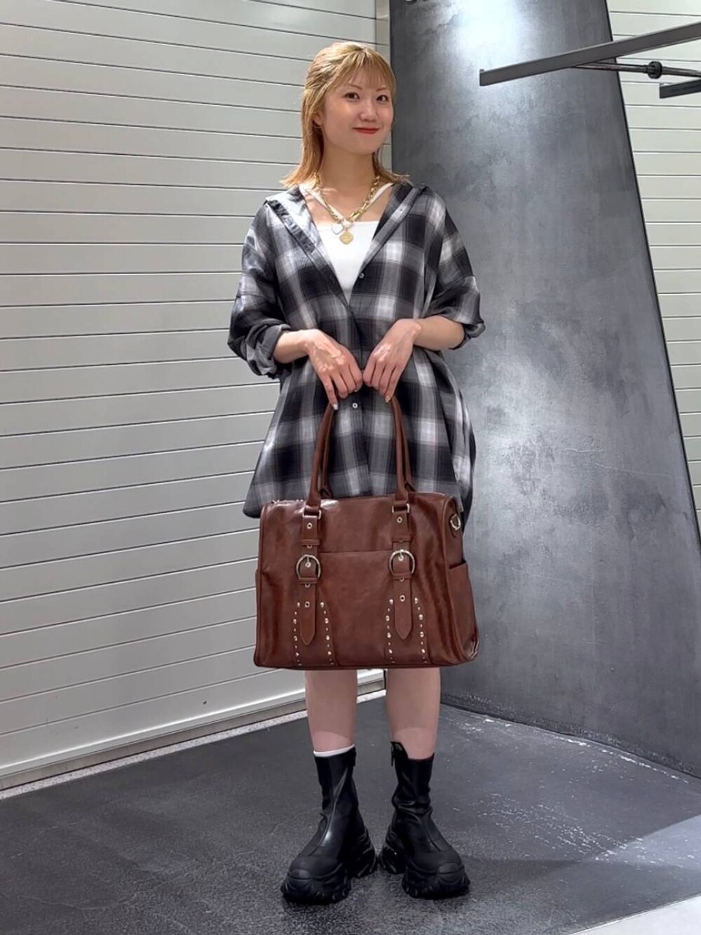 グレー系のシャツ/ブラウス、ブラック系のブーツ、ホワイト系のタンクトップを着用したレディースの秋コーディネートの2枚目の写真