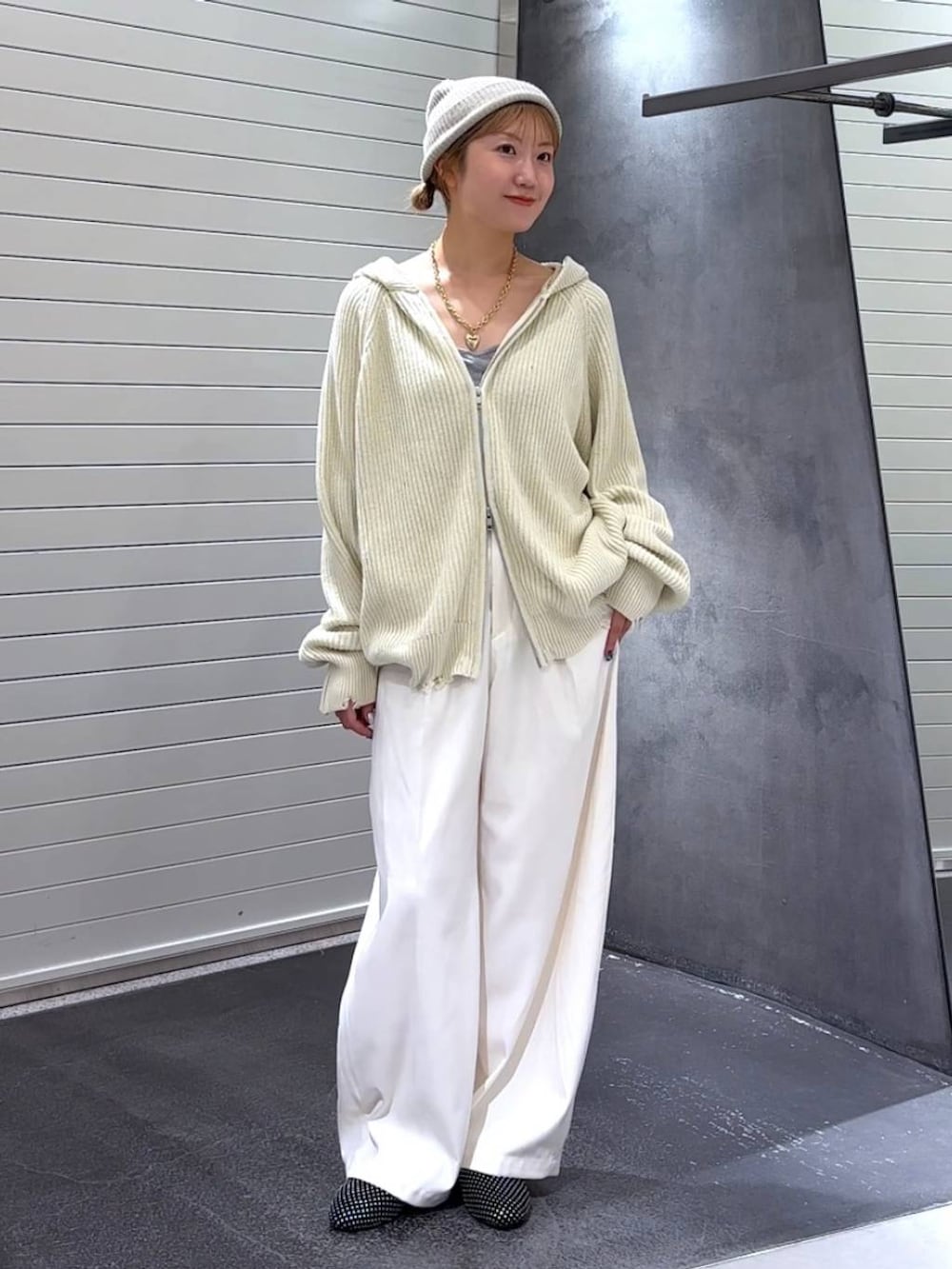 ブラック系のパンプス、ホワイト系のスラックス、ホワイト系のパーカーを着用したレディースの秋コーディネートの3枚目の写真