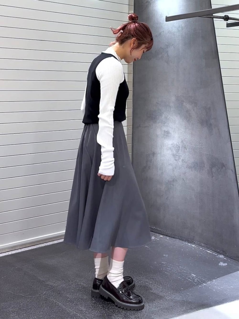 ブラウン系のローファー、ホワイト系のニット/セーター、グレー系のスカートを着用したレディースの秋コーディネートの4枚目の写真