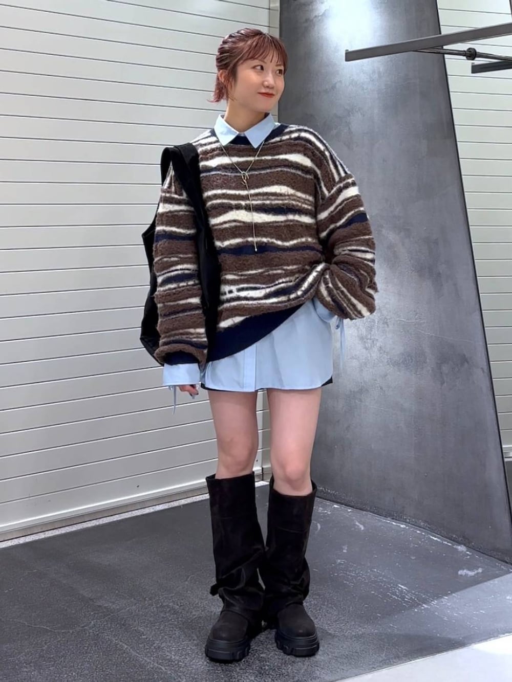 ブラック系のブーツ、ブルー系のシャツ/ブラウス、ブラック系のトートバッグを着用したレディースの秋コーディネートの3枚目の写真