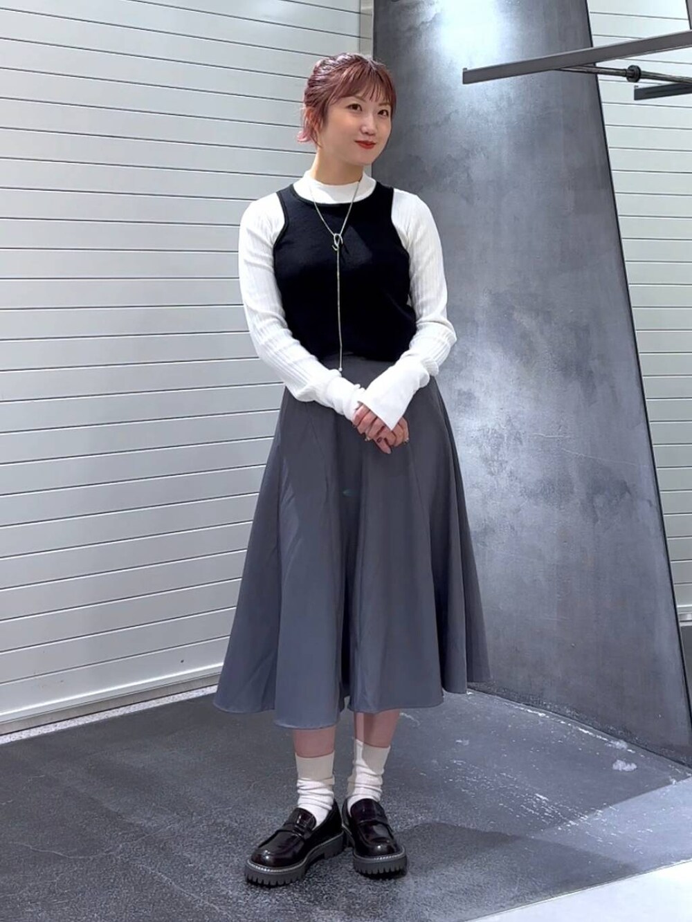 ブラウン系のローファー、ホワイト系のニット/セーター、グレー系のスカートを着用したレディースの秋コーディネートの2枚目の写真