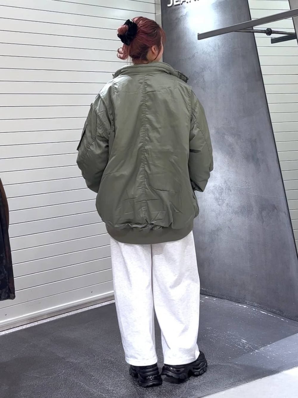 ホワイト系のTシャツ/カットソー、ブラック系のローファー、グリーン系のブルゾンを着用したレディースの冬コーディネートの5枚目の写真