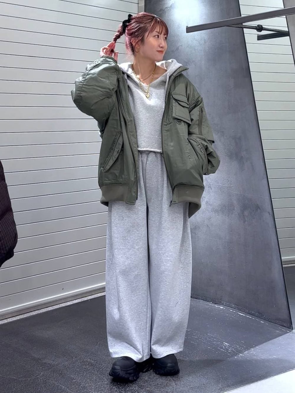 ブラック系のブーツ、グリーン系のブルゾン、グレー系のパーカーを着用したレディースの冬コーディネートの2枚目の写真