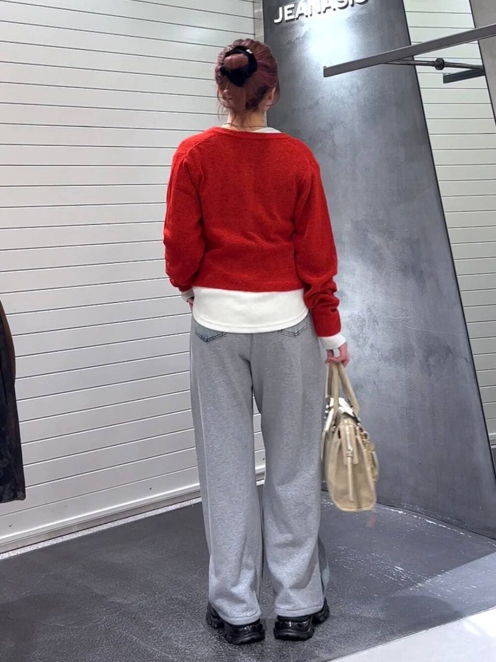 ホワイト系のTシャツ/カットソー、ベージュ系のボストンバッグ、ブラック系のローファーを着用したレディースの冬コーディネートの5枚目の写真