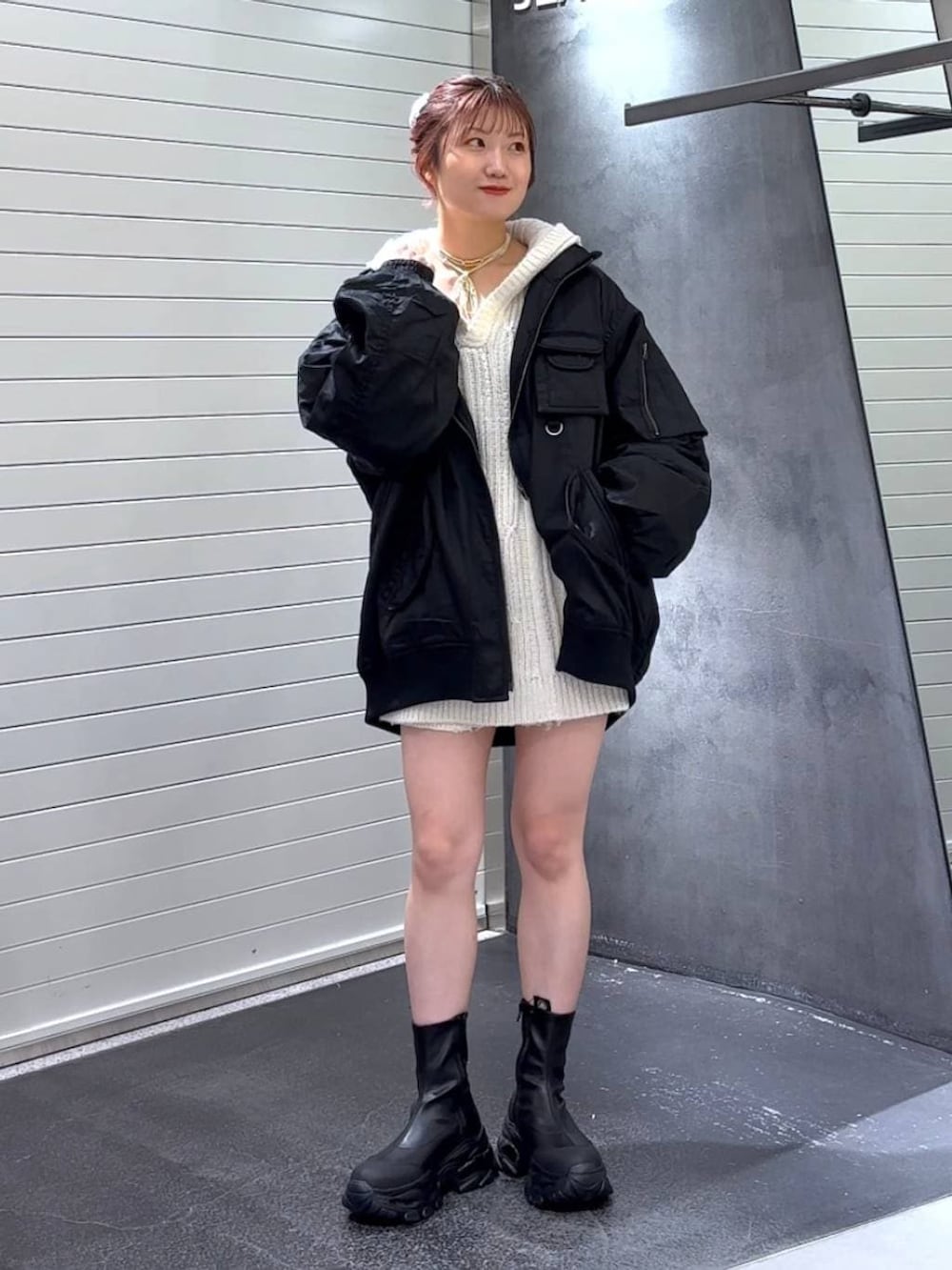 ブラック系のブーツ、ブラック系のブルゾン、ホワイト系のパーカーを着用したレディースの冬コーディネートの3枚目の写真