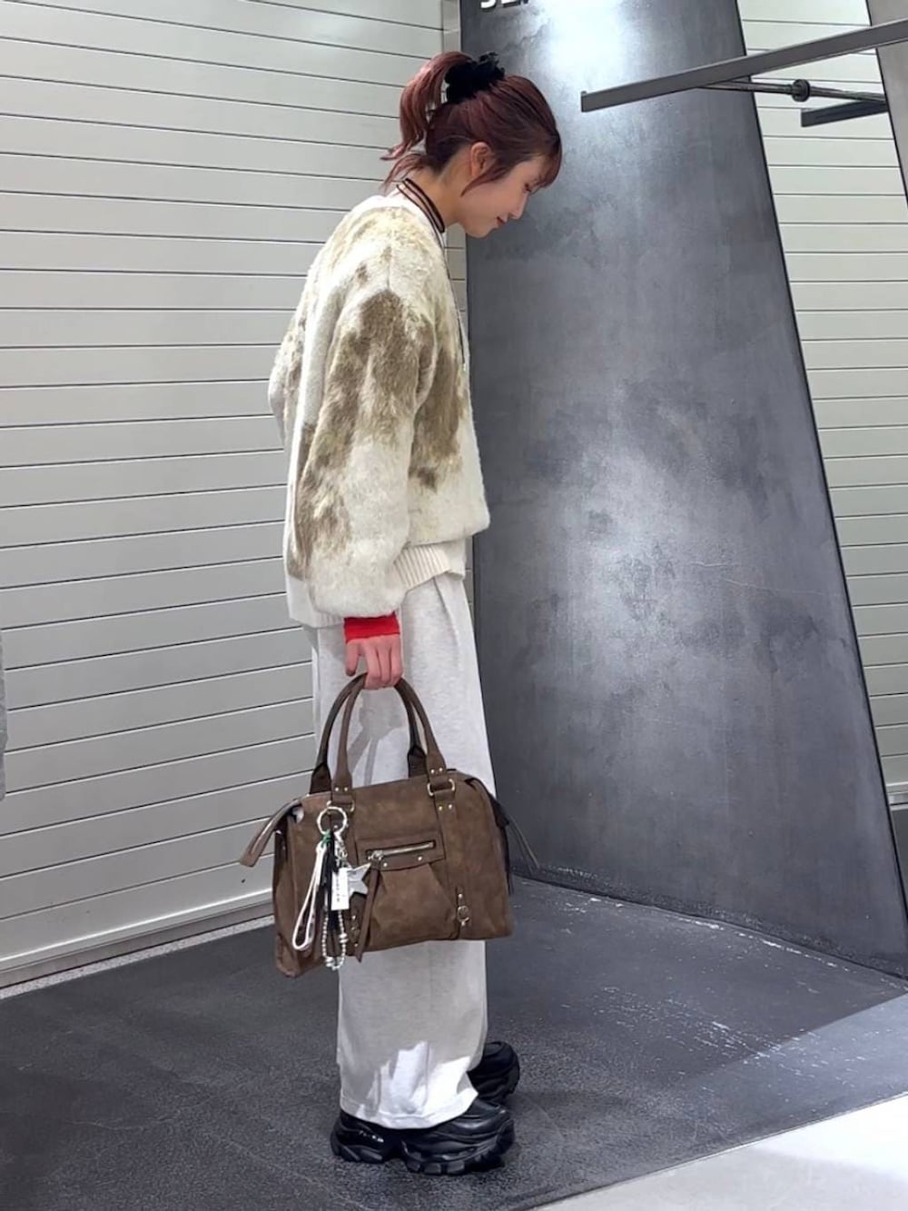 ホワイト系のニット/セーター、ブラウン系のボストンバッグ、ブラック系のローファーを着用したレディースの冬コーディネートの4枚目の写真