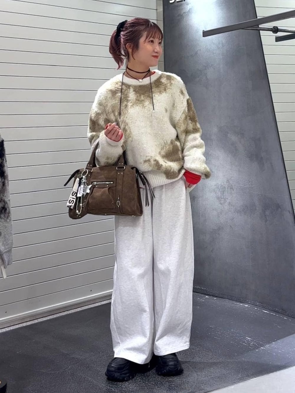 ホワイト系のニット/セーター、ブラウン系のボストンバッグ、ブラック系のローファーを着用したレディースの冬コーディネートの2枚目の写真