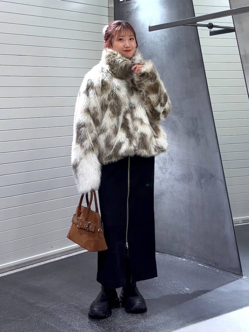 ブラック系のスカート、ホワイト系のブルゾン、ブラック系のブーツを着用したレディースの秋コーディネートの3枚目の写真