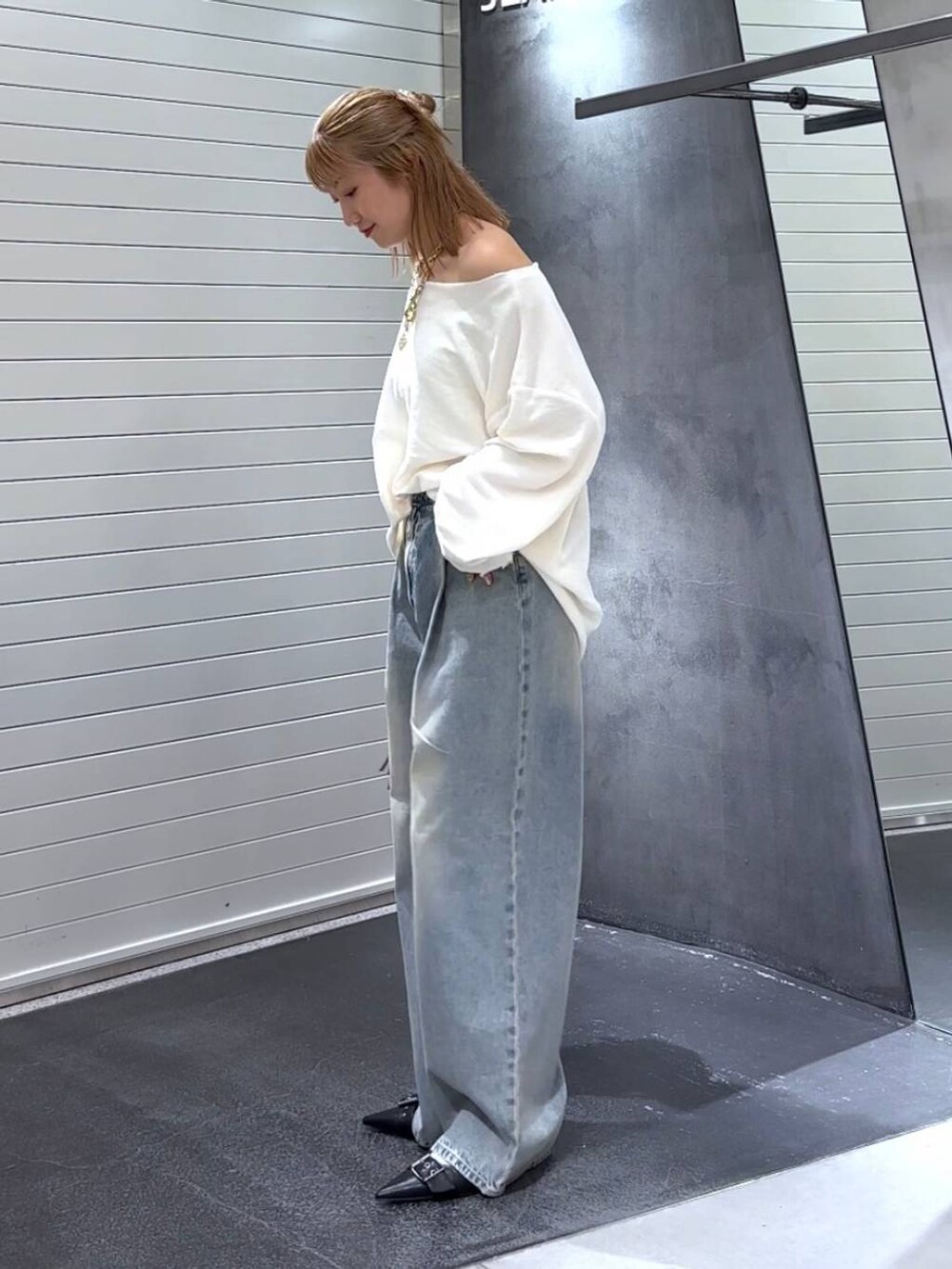 ブルー系のデニムパンツ、ブラック系のパンプス、レッド系のボストンバッグを着用したレディースの秋コーディネートの6枚目の写真