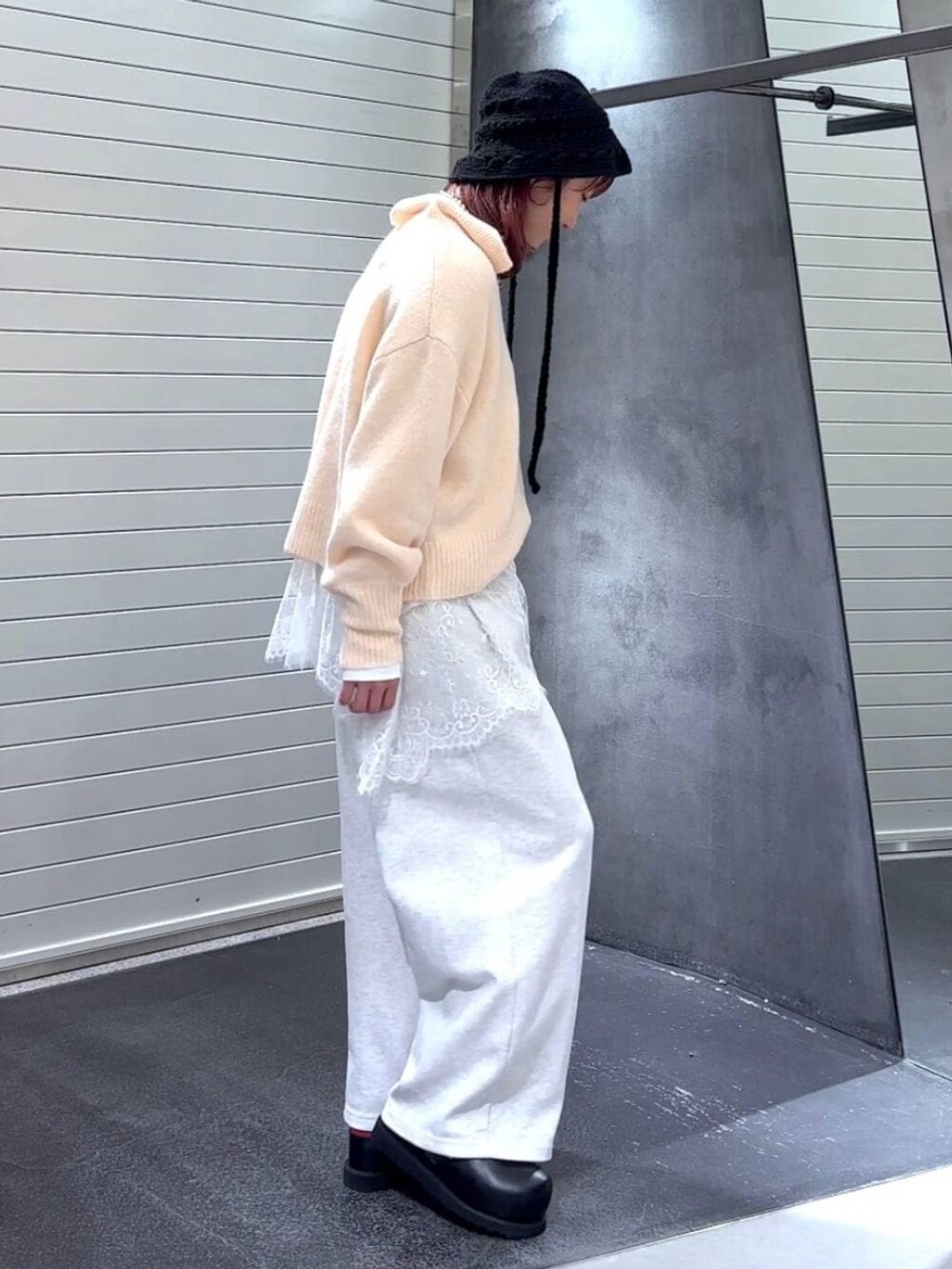 ブラック系のその他シューズ、ホワイト系のTシャツ/カットソー、ベージュ系のスウェットパンツを着用したレディースの冬コーディネートの4枚目の写真