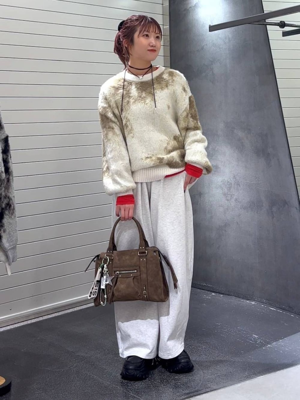 ホワイト系のニット/セーター、ブラウン系のボストンバッグ、ブラック系のローファーを着用したレディースの冬コーディネートの3枚目の写真