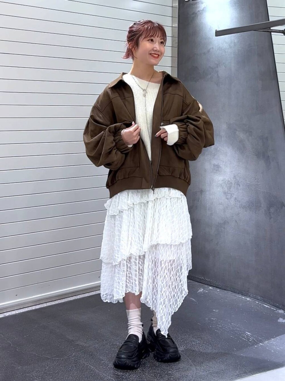 ブラック系のローファー、ホワイト系のスカート、ホワイト系のニット/セーターを着用したレディースの秋コーディネートの3枚目の写真