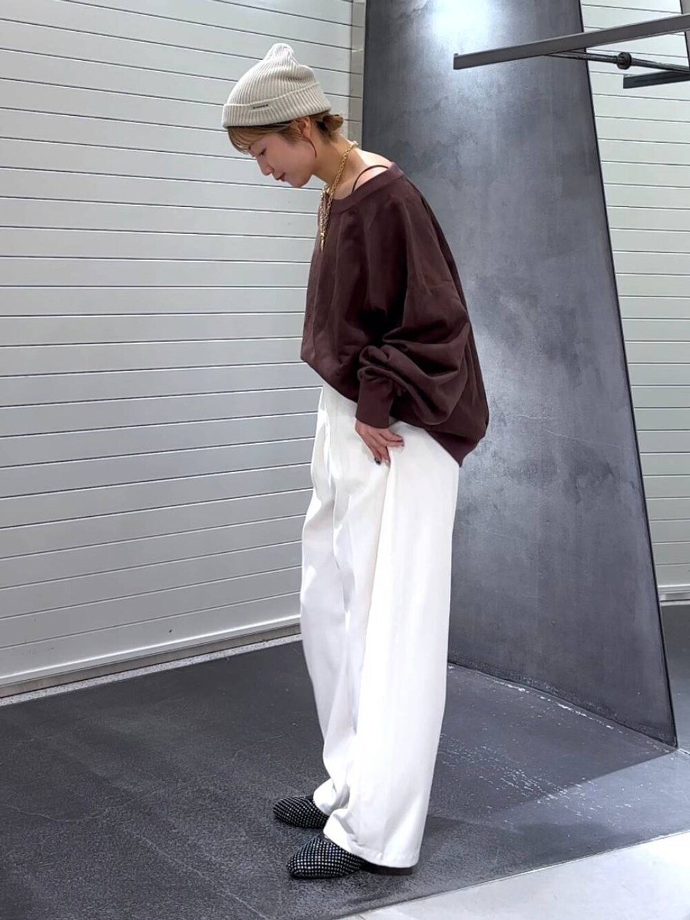 ブラック系のパンプス、ブラウン系のスウェット、ホワイト系のスラックスを着用したレディースの秋コーディネートの6枚目の写真