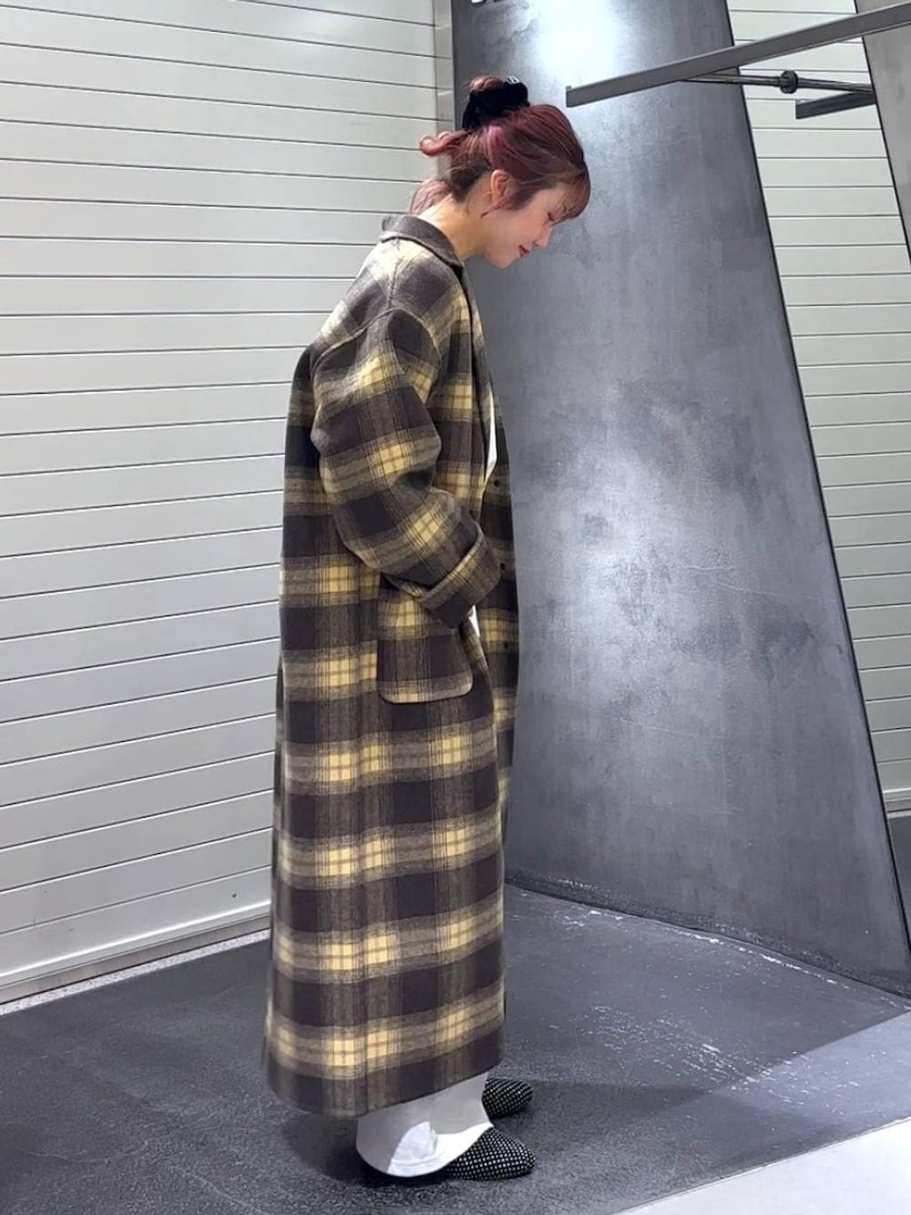 ブラウン系のチェスターコート、ブラック系のパンプス、グレー系のTシャツ/カットソーを着用したレディースの冬コーディネートの4枚目の写真