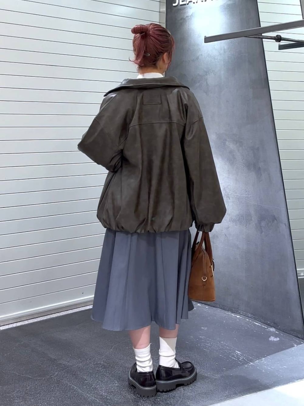 ブラウン系のブルゾン、ブラウン系のローファー、ブラウン系のボストンバッグを着用したレディースの秋コーディネートの5枚目の写真