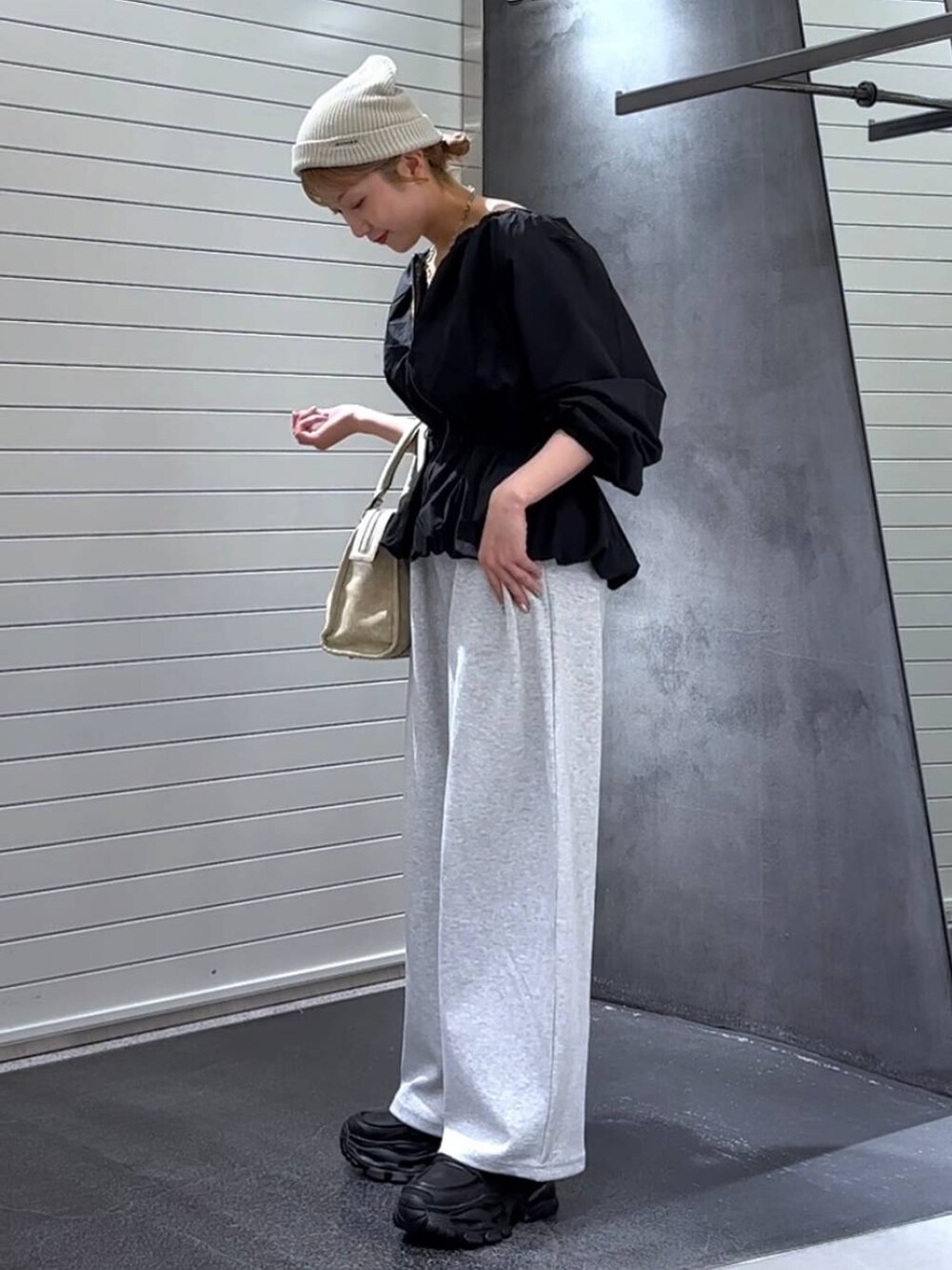 ベージュ系のボストンバッグ、グレー系のスウェットパンツ、ブラック系のローファーを着用したレディースの秋コーディネートの6枚目の写真