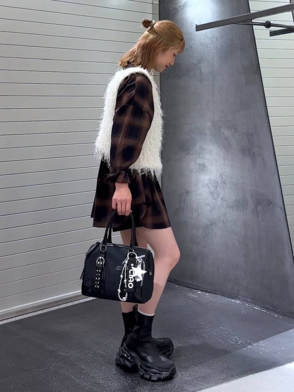 ブラウン系のシャツ/ブラウス、ブラック系のブーツ、ブラック系のボストンバッグを着用したレディースの秋コーディネートの4枚目の写真