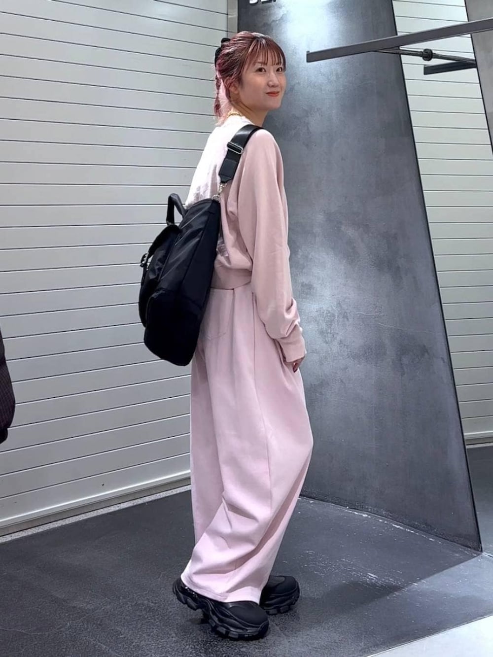 ブラック系のブーツ、ブラック系のトートバッグ、ピンク系のスウェットを着用したレディースの冬コーディネートの4枚目の写真