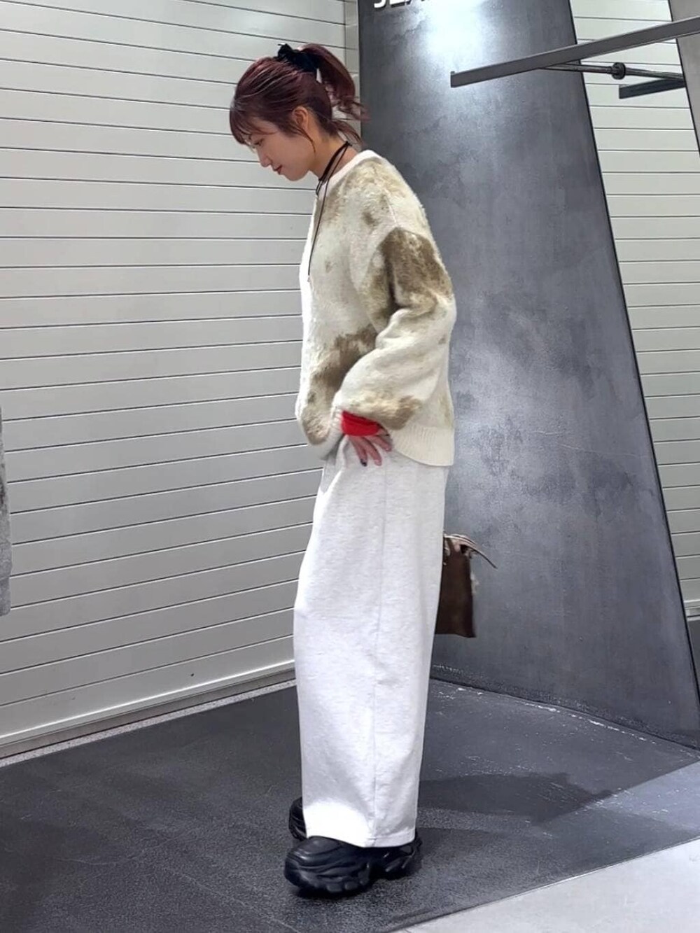 ホワイト系のニット/セーター、ブラウン系のボストンバッグ、ブラック系のローファーを着用したレディースの冬コーディネートの6枚目の写真