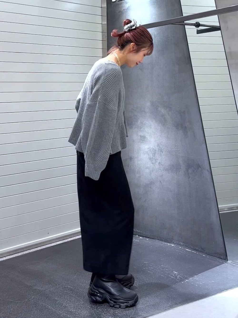 ブラック系のスカート、ブラック系のブーツ、グレー系のカーディガン/ボレロを着用したレディースの秋コーディネートの4枚目の写真