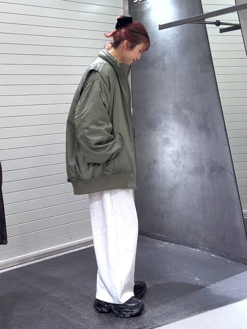 ホワイト系のTシャツ/カットソー、ブラック系のローファー、グリーン系のブルゾンを着用したレディースの冬コーディネートの4枚目の写真