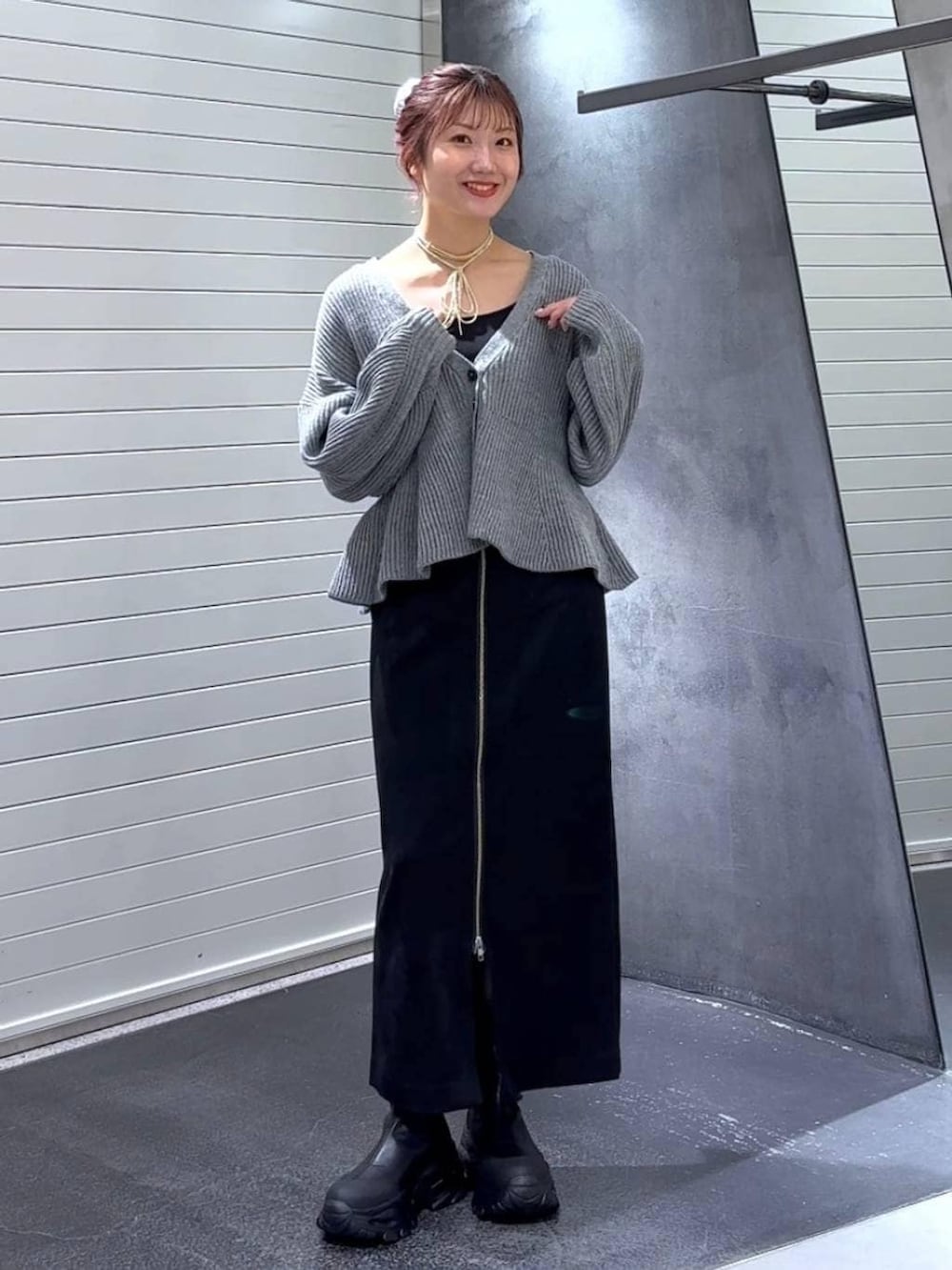 ブラック系のスカート、ブラック系のブーツ、グレー系のカーディガン/ボレロを着用したレディースの秋コーディネートの3枚目の写真