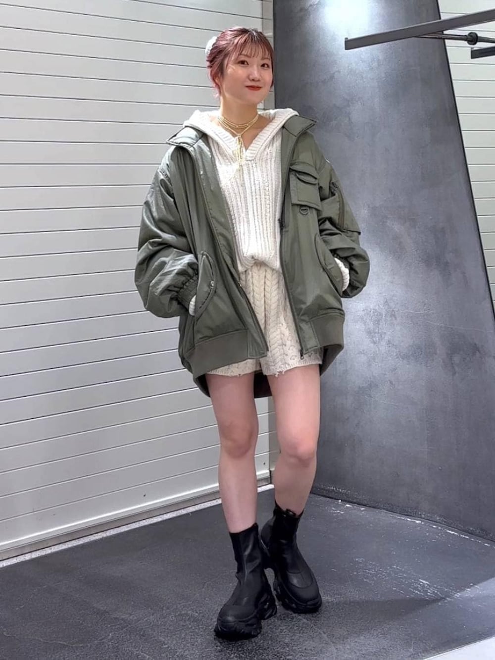 ブラック系のブーツ、グリーン系のブルゾン、ホワイト系のパーカーを着用したレディースの秋コーディネートの3枚目の写真