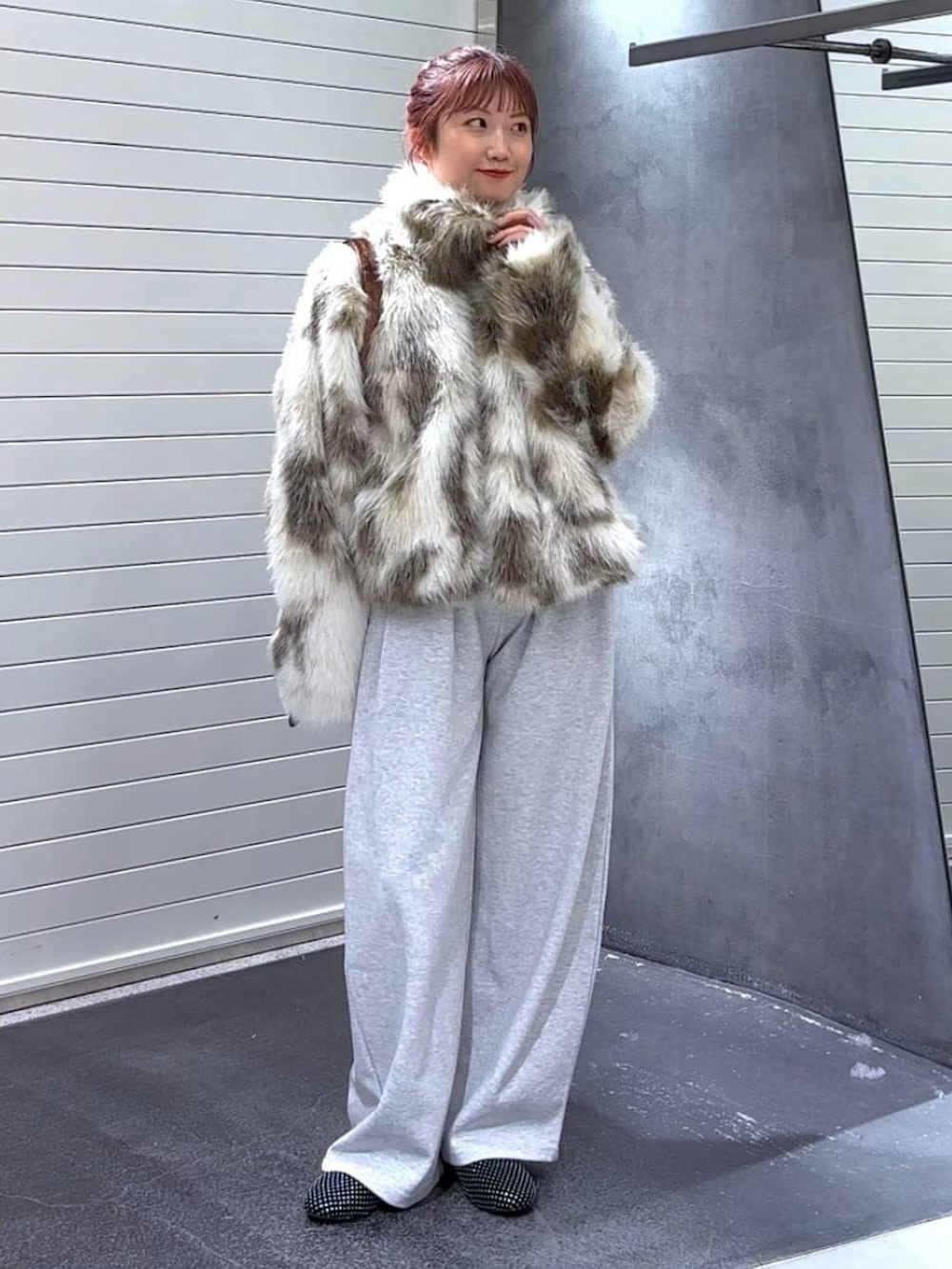 ホワイト系のブルゾン、ブラウン系のトートバッグ、グレー系のスウェットパンツを着用したレディースの冬コーディネートの2枚目の写真