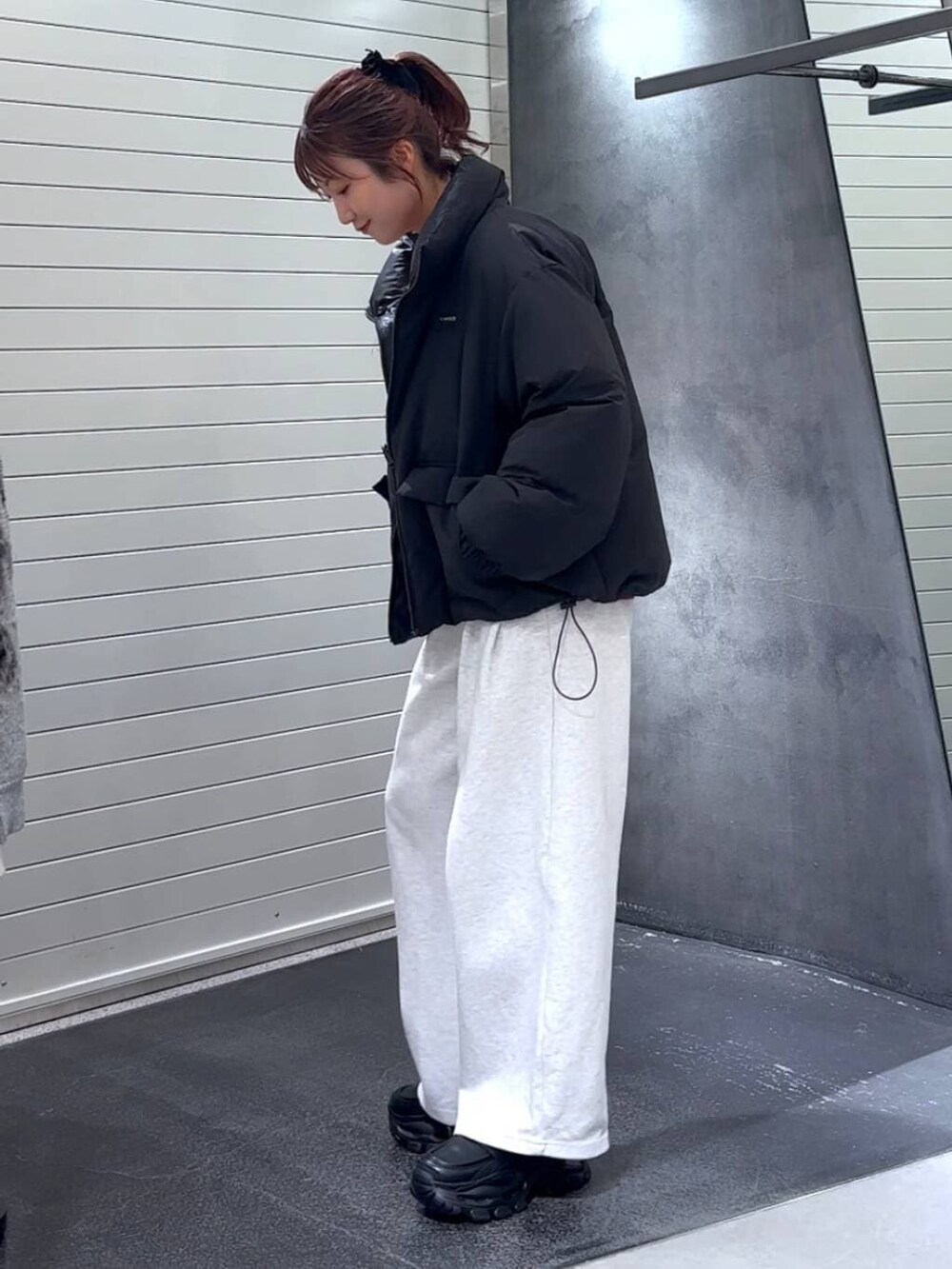 ブラック系のブルゾン、ブラック系のローファー、ベージュ系のスウェットパンツを着用したレディースの冬コーディネートの6枚目の写真