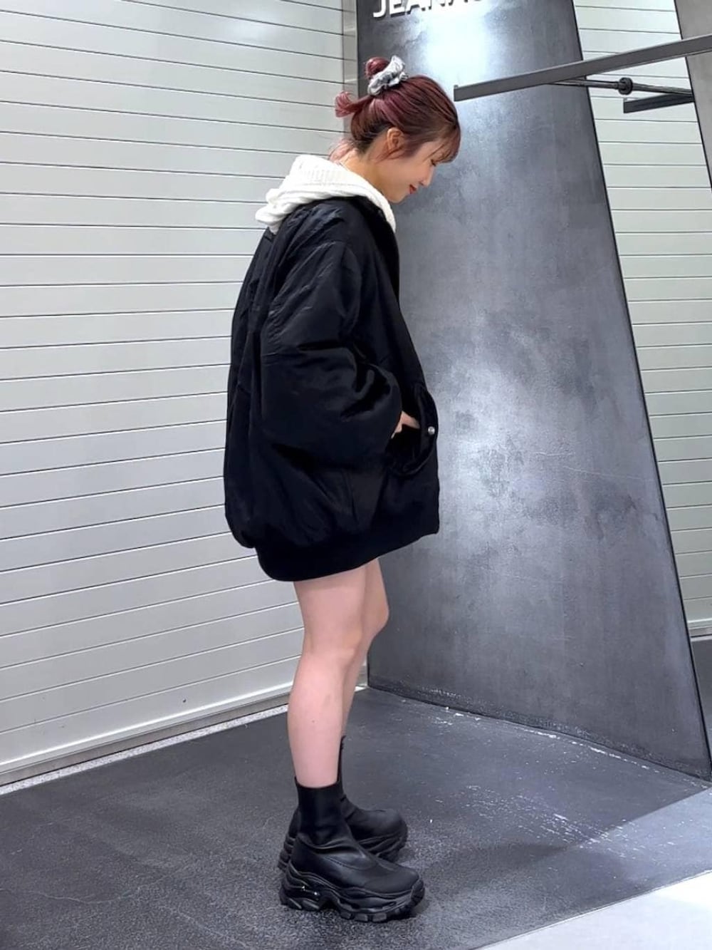 ブラック系のブーツ、ブラック系のブルゾン、ホワイト系のパーカーを着用したレディースの冬コーディネートの4枚目の写真