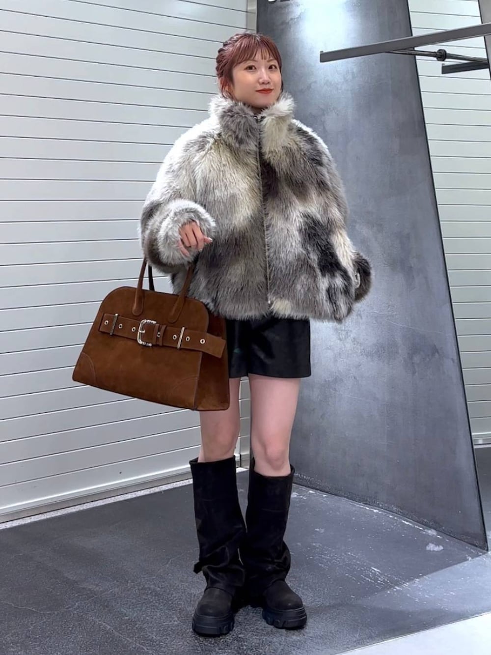 グレー系のブルゾン、ブラック系のブーツ、ブラウン系のショルダーバッグを着用したレディースの秋コーディネートの3枚目の写真