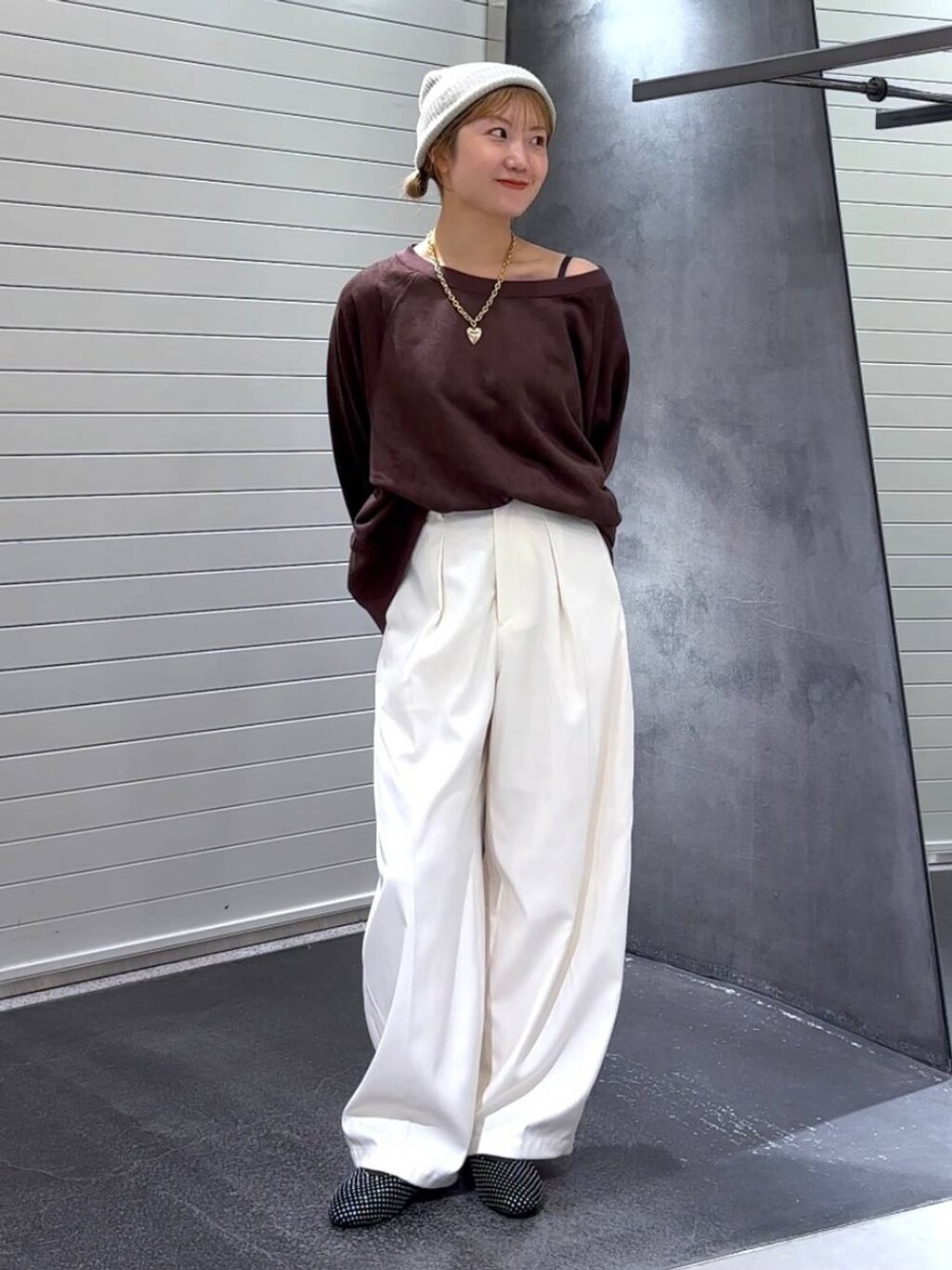 ブラック系のパンプス、ブラウン系のスウェット、ホワイト系のスラックスを着用したレディースの秋コーディネートの2枚目の写真