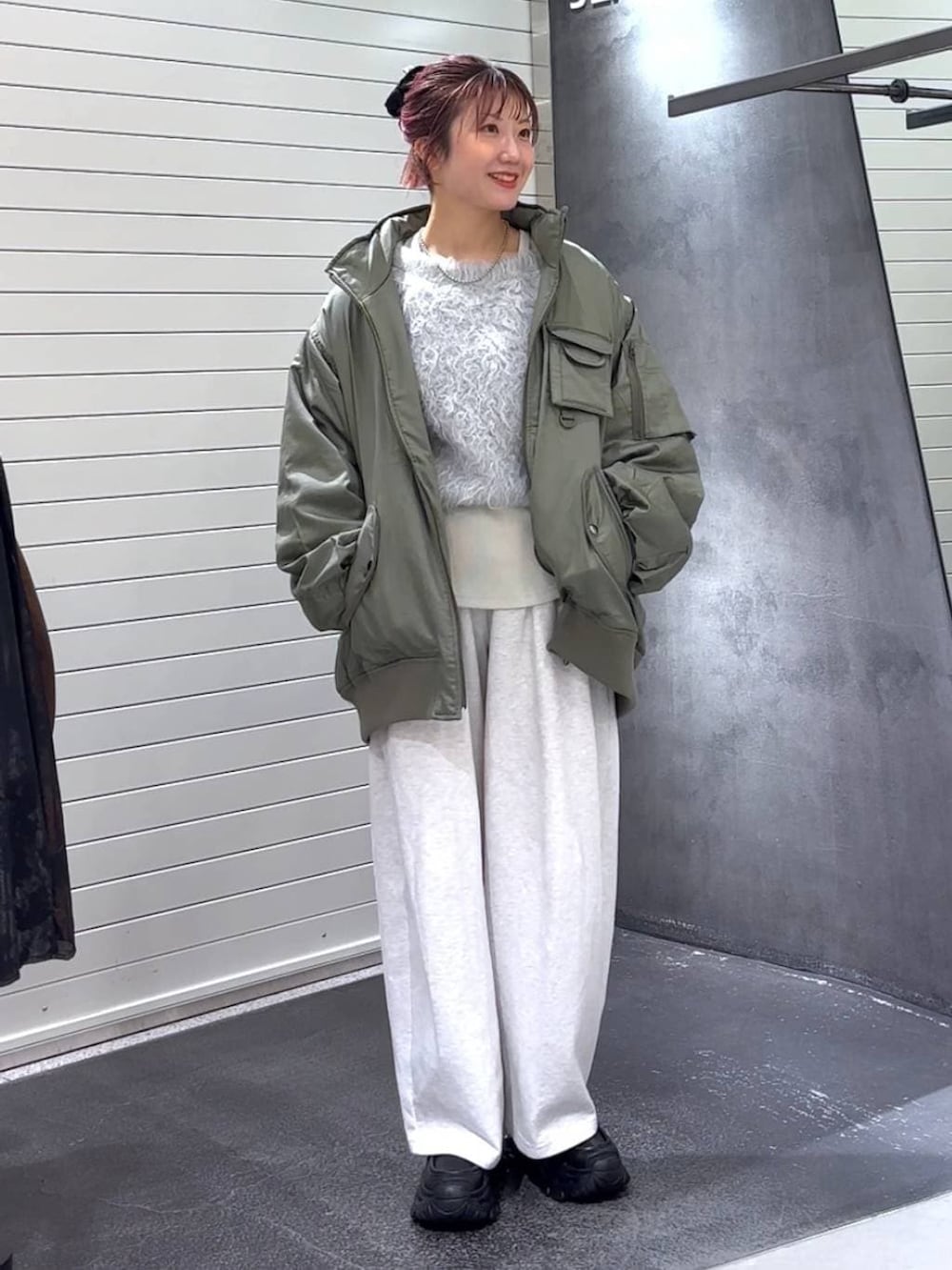 ホワイト系のTシャツ/カットソー、ブラック系のローファー、グリーン系のブルゾンを着用したレディースの冬コーディネートの2枚目の写真
