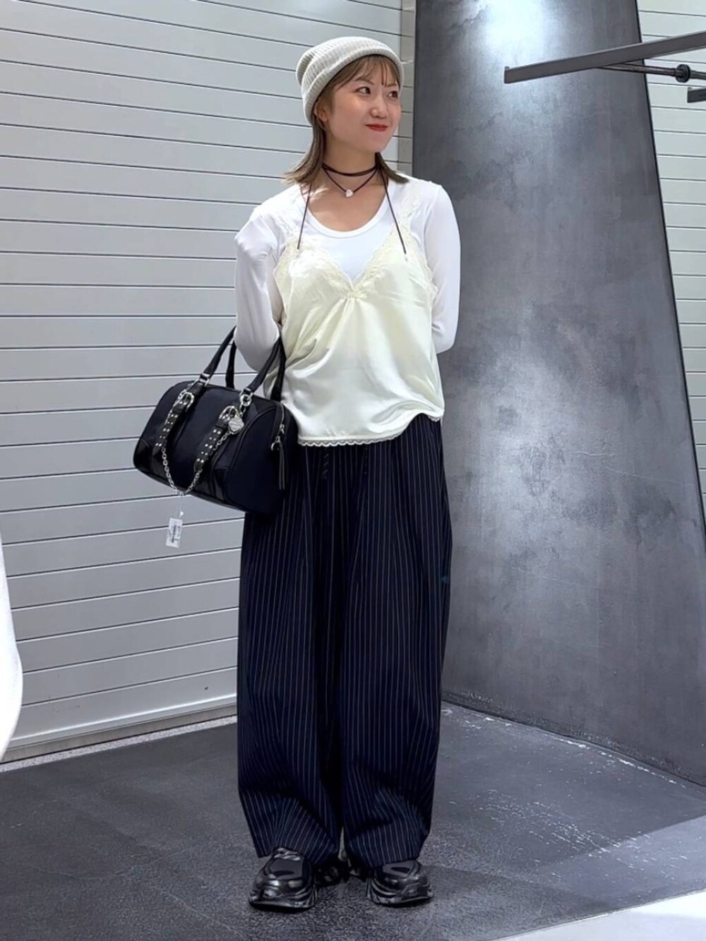 ホワイト系のTシャツ/カットソー、ブラック系のスニーカー、ブルー系のスラックスを着用したレディースの秋コーディネートの3枚目の写真