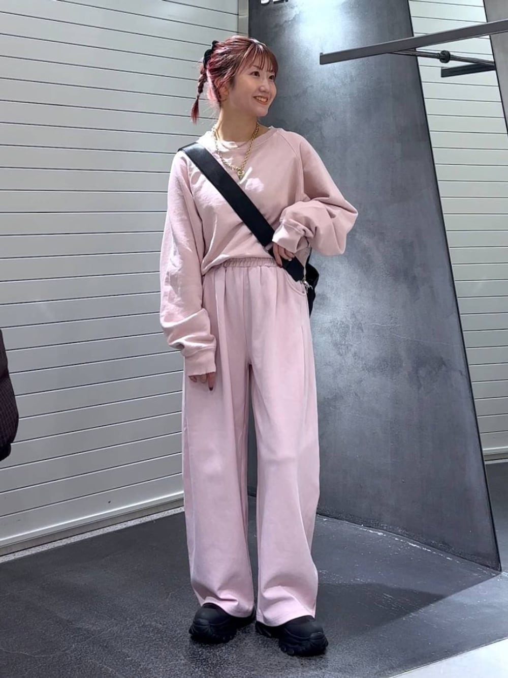 ブラック系のブーツ、ブラック系のトートバッグ、ピンク系のスウェットを着用したレディースの冬コーディネートの2枚目の写真